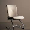 Voici une chaise de bureau minimaliste en laine beige avec un piètement en acier luge